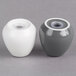 Two white porcelain salt and pepper shakers with grey lids.
