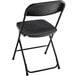A Lancaster Table & Seating black folding chair with a black seat.