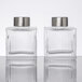Two American Metalcraft clear glass ribbed square salt and pepper shakers with silver tops.