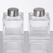 Two clear glass American Metalcraft ribbed square salt and pepper shakers with silver lids.