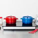 A Vollrath countertop induction warmer with a red and blue pot on it.