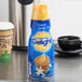 A plastic bottle of International Delight French Vanilla coffee creamer on a counter.