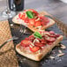A piece of European Bakers ciabatta bread with strawberries and almonds on a plate.