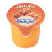 A close up of a container of International Delight Hazelnut Single Serve Non-Dairy Creamer.
