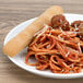 A plate of spaghetti and meatballs with Rich's Italian bread.