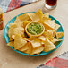 A plate of Mission yellow corn tortilla chips with guacamole.