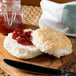 A Bakery Chef buttermilk biscuit with jam on a wooden board.