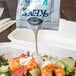 A shrimp salad with Ken's Foods Ranch Dressing being poured from a white packet.