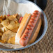 A bowl of hot dog and chips with a European Bakers New England hotdog bun.