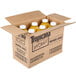 A cardboard box with Tropicana orange juice bottles inside.