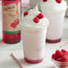 Two milkshakes with whipped cream and DaVinci Gourmet raspberry syrup with raspberries on top.
