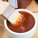 A brush over a bowl of Sweet Baby Ray's Sweet Red Chili Pepper Wing Sauce