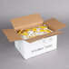 A cardboard box filled with yellow 5.5 gram yellow mustard portion packets.