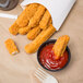 Brakebush Gold'N'Spice Chik'N Fry Stix in a container with ketchup.