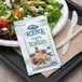 A salad on a tray with a Ken's Foods Creamy Italian dressing packet.