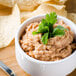 A bowl of Old El Paso refried beans with tortilla chips.