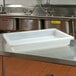 A white Cambro food storage box on a metal table.