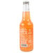 A close-up of a bottle of Izze Sparkling Grapefruit Juice with orange liquid inside.