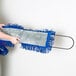 A person holding a blue and grey Lavex All-In-One Microfiber Dust / Dry Mop handle.
