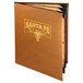 A brown leather Menu Solutions Bella Collection menu cover with a logo in gold on a table in a Mexican restaurant.