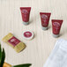 A group of small tubes of Noble Eco Novo Natura hotel and motel shampoo with a towel.