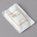 A white package with gold text that reads "Novo Essentials Hotel and Motel Shower Cap"