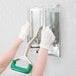 A person in white gloves using a Garde heavy-duty French fry cutter wall mount.