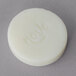 A white round Noble Eco hotel soap disc with the word "Novo" on it.