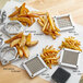 A Garde heavy-duty French fry cutter on a counter with a pile of fries and a square metal grate with holes.