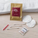 A white towel, a toothbrush, and a packet of cotton in a clear bag with a Noble Eco Novo Natura label.