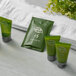 A green package of Noble Eco Novo Terra hotel grooming products next to a white towel.
