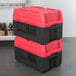A stack of red and black Metro Mightylite food pan carriers.