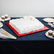 An 18" red fold-under square cake drum with a white cake on top.