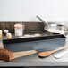 A Matfer Bourgeat non-stick steel bread loaf pan on a counter with a loaf of bread and cookies.