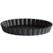 A black round Matfer Bourgeat fluted tart pan with a removable bottom.