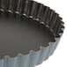 A close-up of a Matfer Bourgeat fluted metal quiche pan.