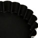 A Matfer Bourgeat fluted black steel tartlet/quiche mold with a scalloped edge.