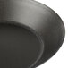 A close up of a Matfer Bourgeat black steel tartlet/quiche mold.