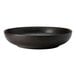 A white porcelain deep coupe bowl with a black speckled texture.
