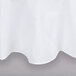 A close-up of a white Intedge round tablecloth with a hemmed edge.