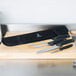 A Mercer Culinary knife roll with knives on a cutting board.
