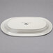 A white oval Tuxton China platter with an embossed rim.