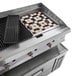 A stainless steel Cooking Performance Group gas lava briquette charbroiler on a table with a refrigerated chef base.