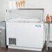 A white Avantco hinged lid cover on a commercial ice cream freezer.