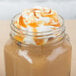 A glass jar of Ghirardelli Sea Salt Caramel Flavoring Sauce with a liquid in it.