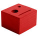 A red wooden block with holes and a face.