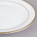 A close up of a CAC white porcelain plate with gold trim.