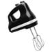 A black KitchenAid hand mixer with a silver handle and cord.