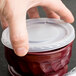 A hand holding a Dinex translucent plastic bowl lid.