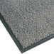 A close-up of a grey Notrax carpet entrance floor mat with black trim.